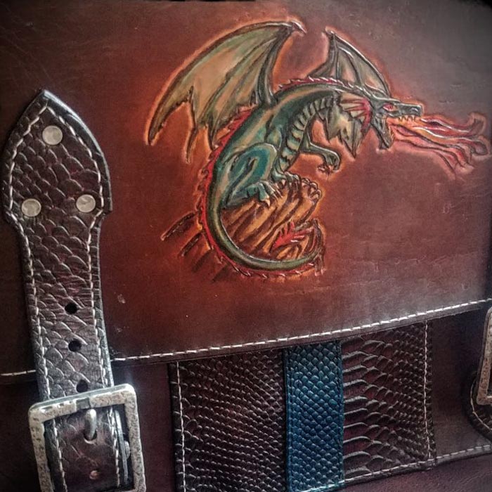 Dark brown leather bag with various textures and a green fire breathing dragon on the top flap.
