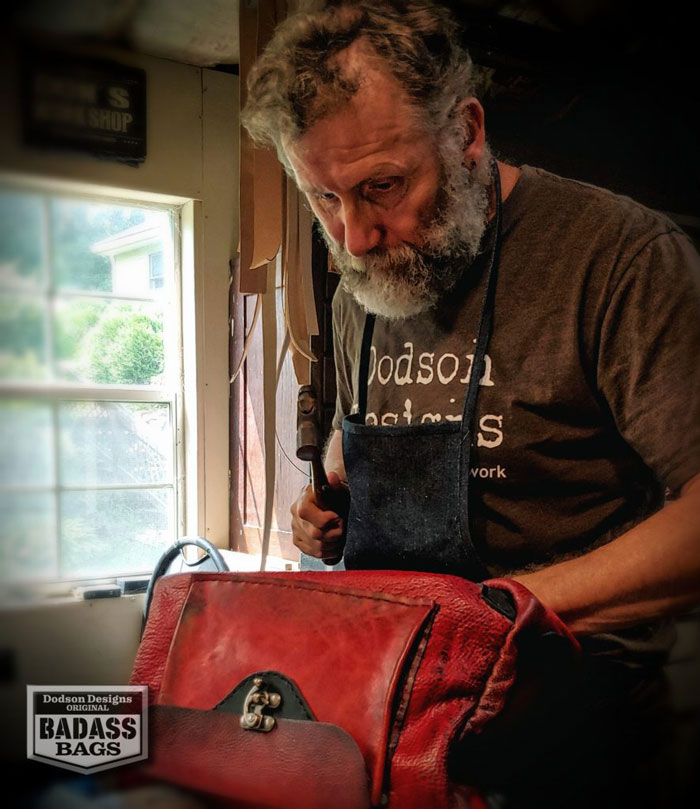 Don assembling a red leather badass bag.