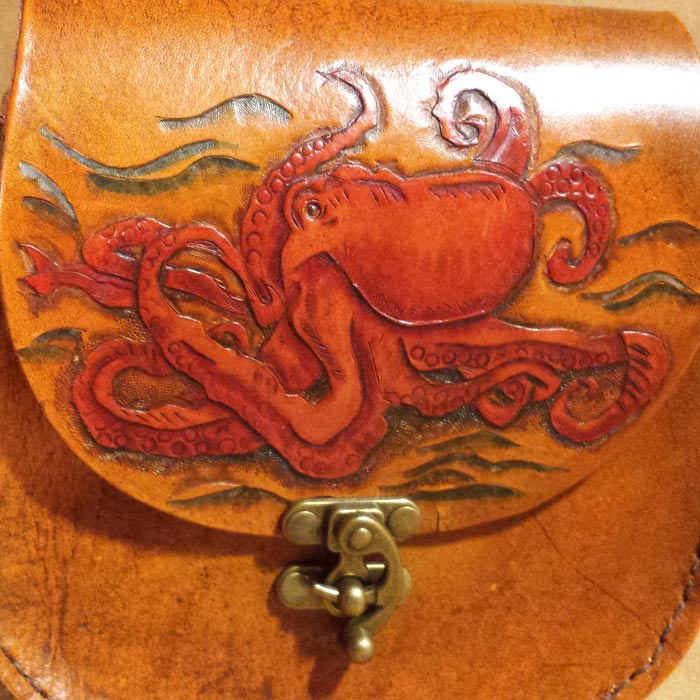 Tan leather pouch with red octopus tooling detail.
