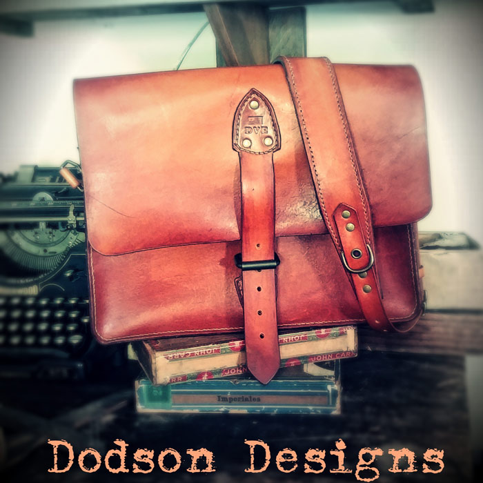 Tan soft leather hand made messenger bag with wrap around strap closure.