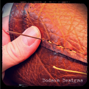 Hand stitching elements of a soft leather bag.